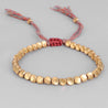 Un bracelet style macramé avec un tissage fin et perles en cuivres