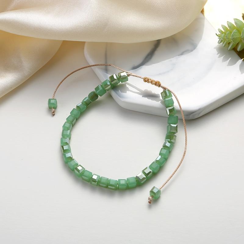 Découvrez notre bracelet jade avec son fin tissage fait-main en macramé et ses cristaux cubiques teintés