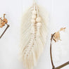 Craquez pour une belle plume en macramé blanche décorée de perles en bois